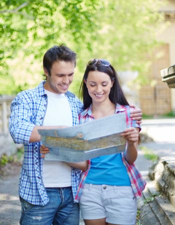 smiling-couple-looking-city-map